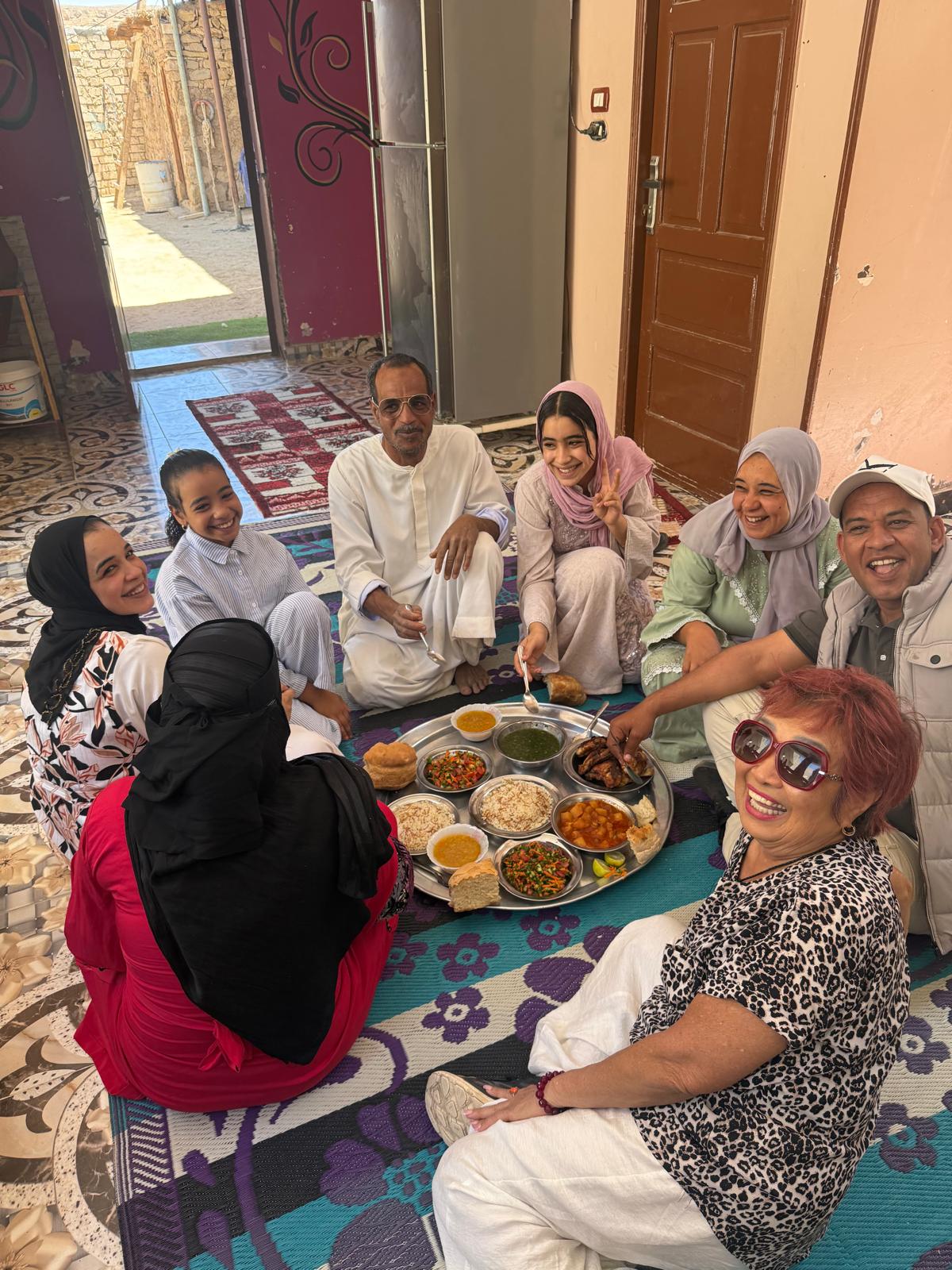 Travelers sharing a meal with a local family in Egypt