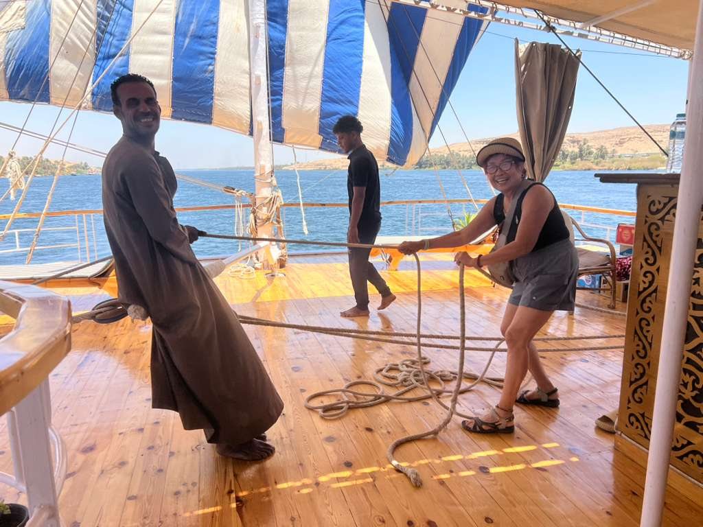 Traveler helping with the sail on a Nile dahabiya