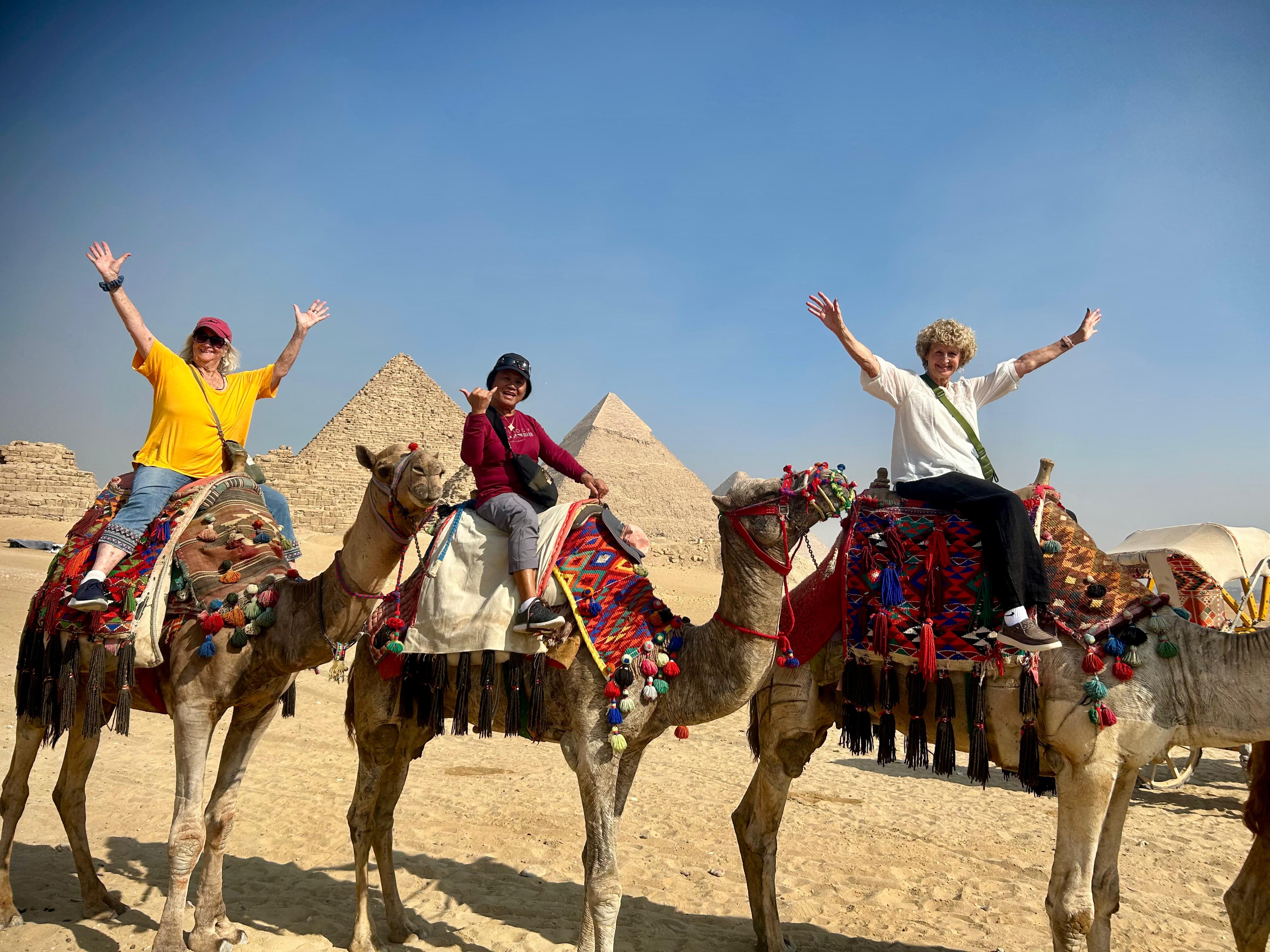 Travelers riding camels near the Pyramids of Giza