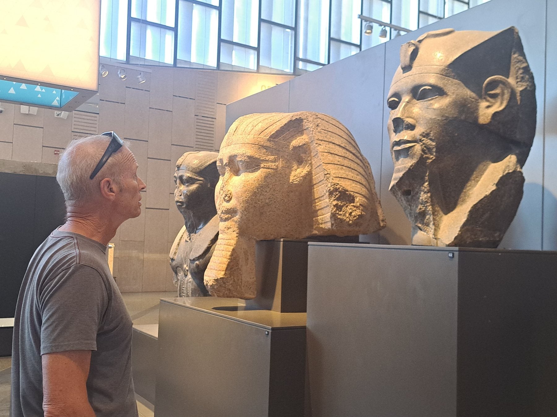Traveler looking at monumental statues inside the Grand Egyptian Museum