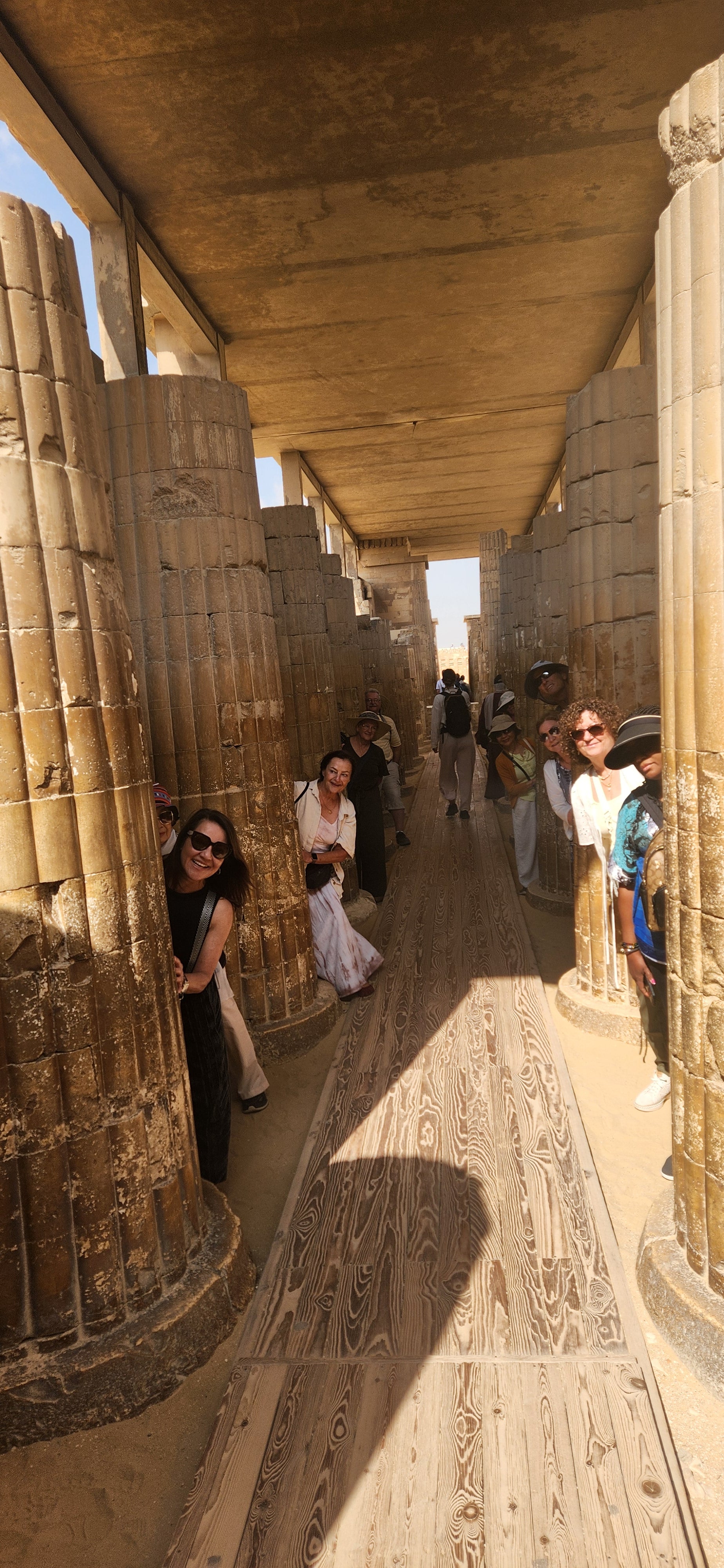 Travelers walking through a temple walkway in Luxor